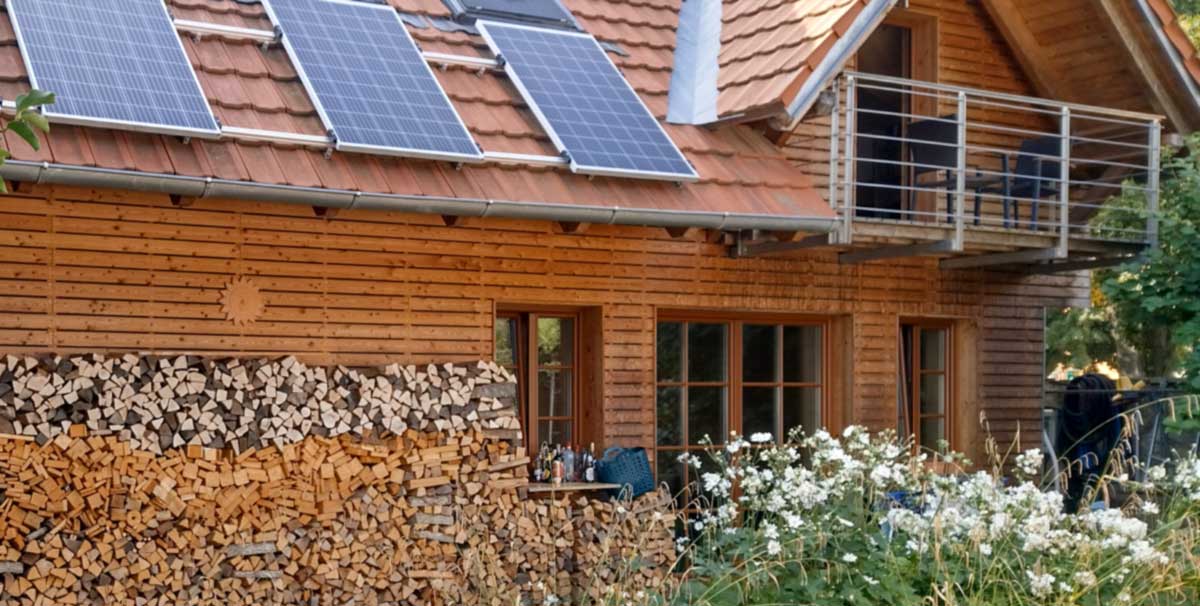 Holzhaus mit Pv-Anlage und einem Holzstoß